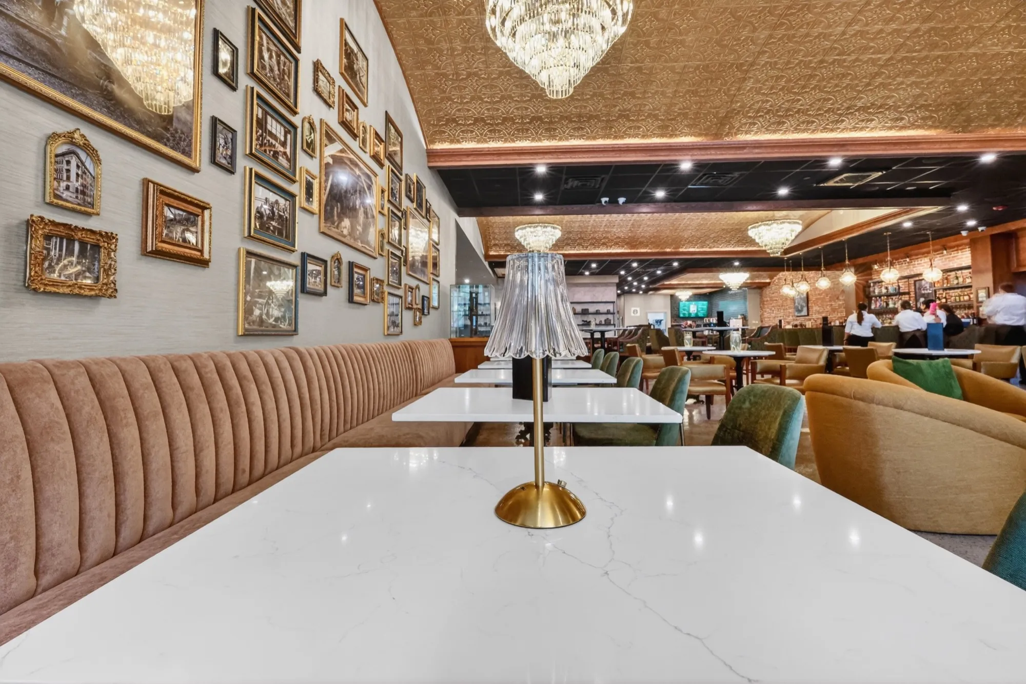 The café dining room with banquette seating beneath a wall of framed photographs