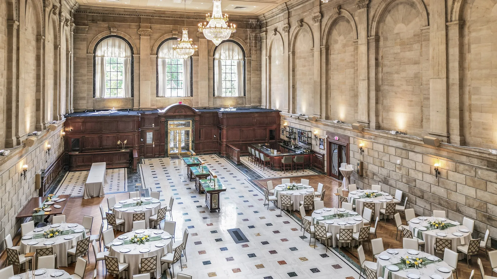 The grand hall set with round tables and floral centerpieces for a seasonal dinner
