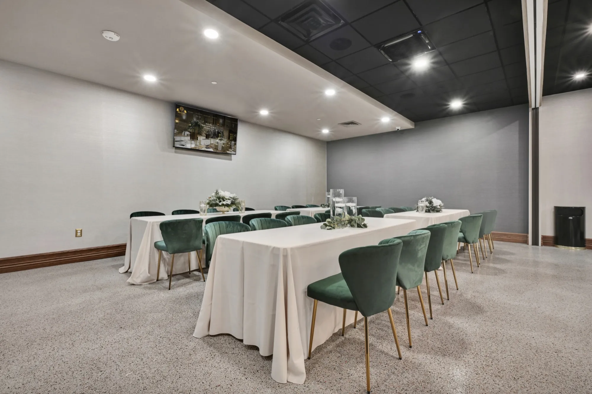 An event room set with a long banquet table and velvet chairs