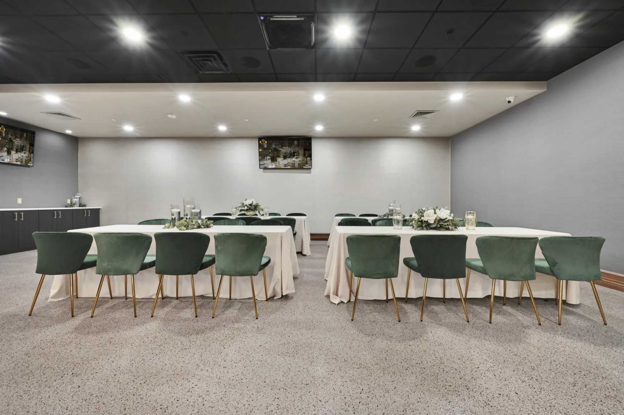 A meeting room arranged with banquet seating and a presentation screen
