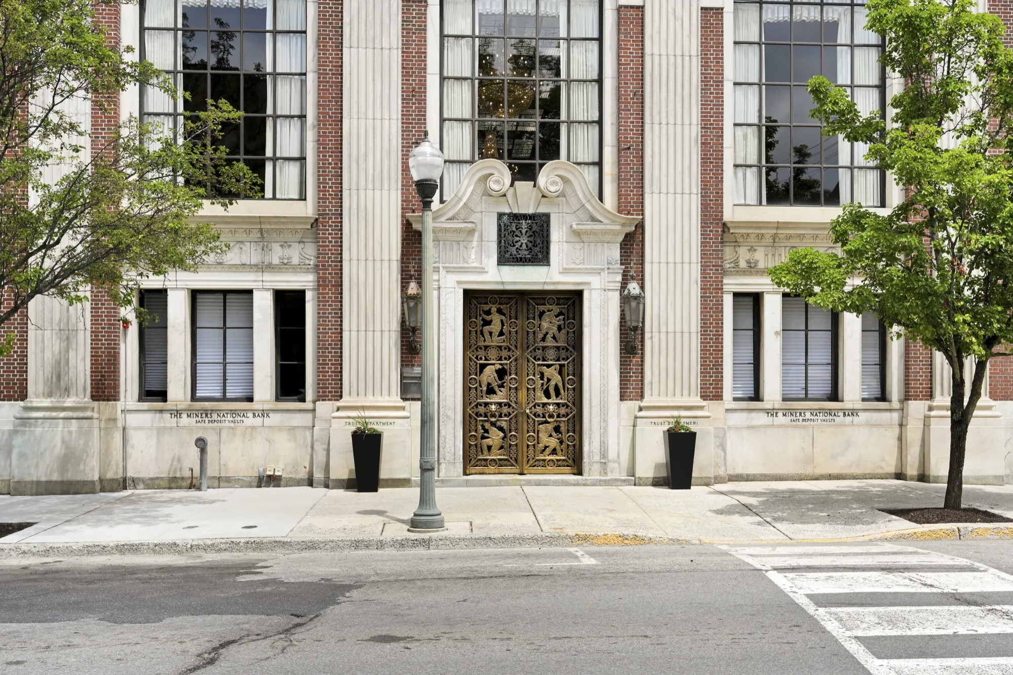 The monumental ten-foot brass Polachek entrance doors of The Miners 1928
