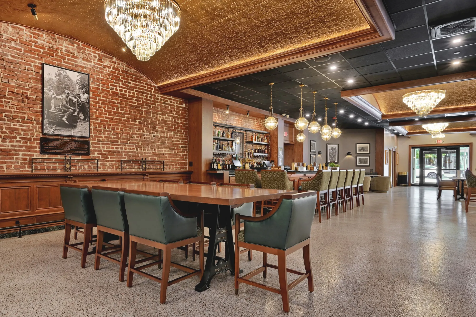 The seating area at Lounge 28, with brick walls, chandeliers, and the bar beyond