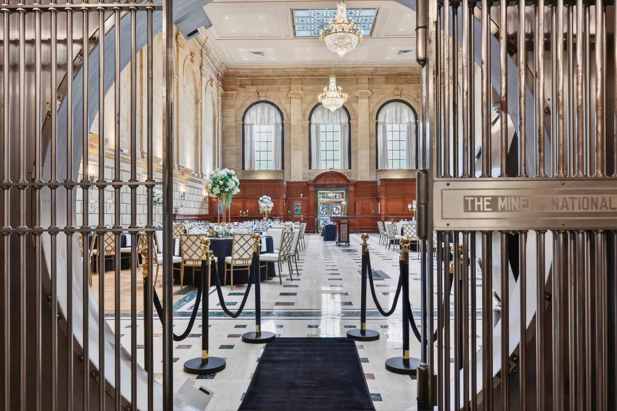 The view through the brass gates into the banking hall, set for a ceremony with an aisle runner