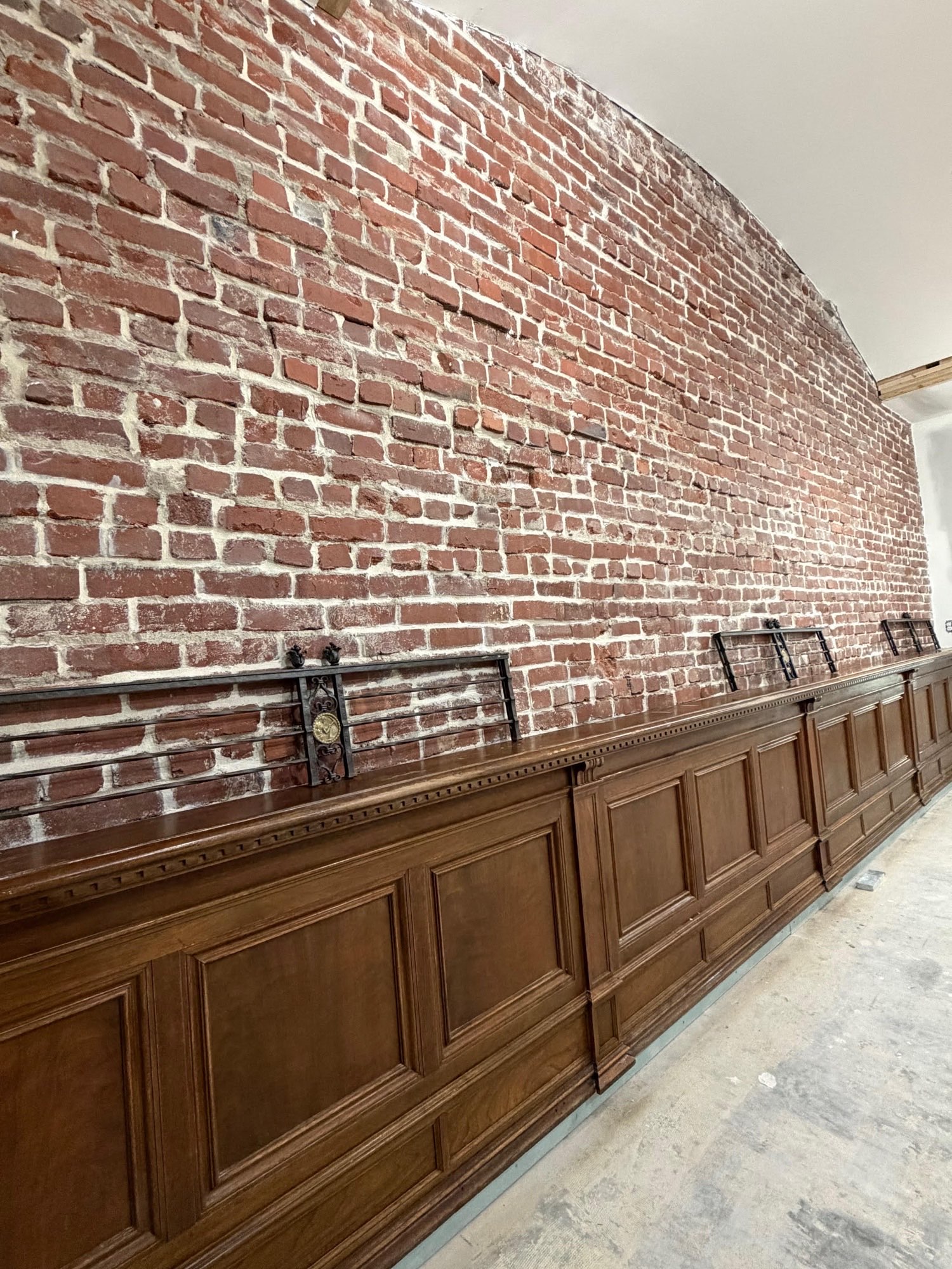 The 28 Lounge featuring curved exposed brick walls and elegant wood wainscoting